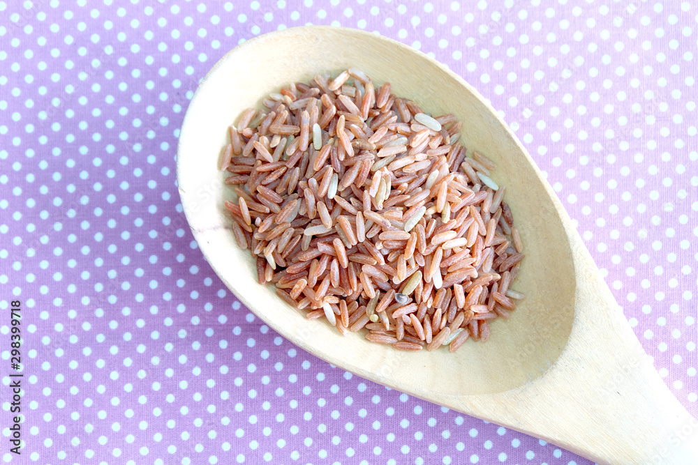 red rice in wooden spoon red rice in wooden spoon