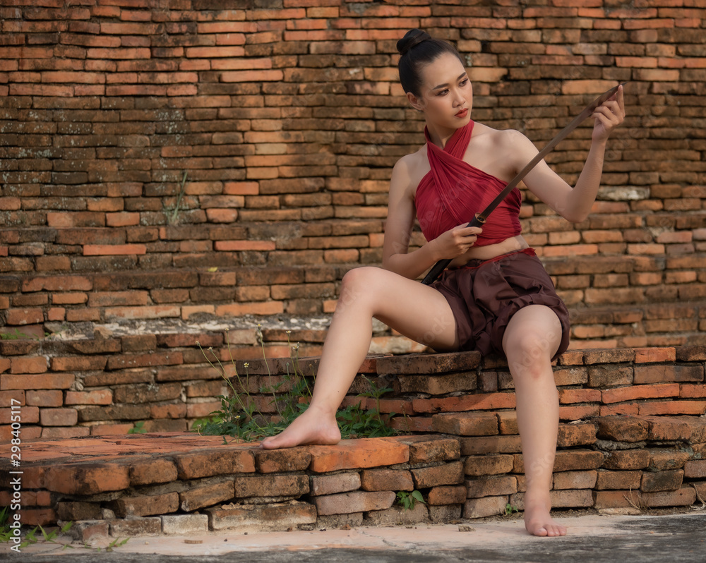 Young Thai warrior woman with double swords dress in old style fantasy. Young Thai warrior woman with double swords dress in old style fantasy.