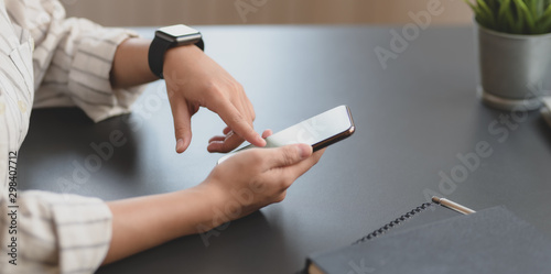 Close-up view of young professional businesswoman touching blank screen smartphone