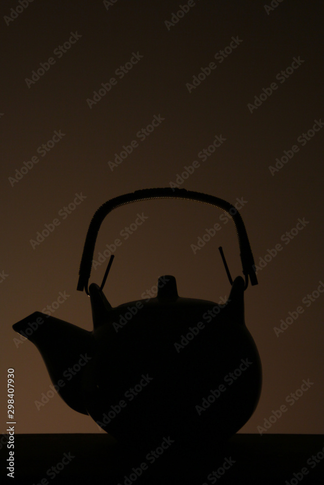 black silhouette of teapot and a cup of hot tea black silhouette of teapot and a cup of hot tea