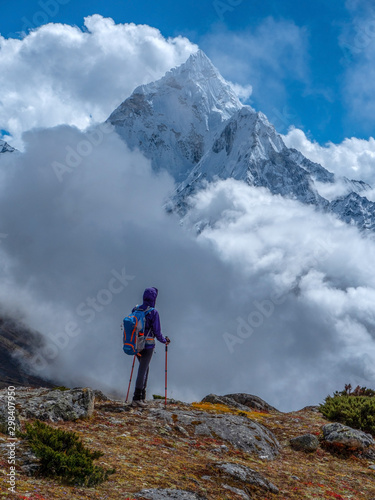 Active hiker hiking, enjoying the view of Ama Dablam mount, looking at Himalaya mountains landscape. Travel sport lifestyle concept