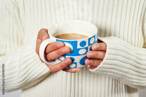 warm cup of hot coffee warming in the hands of a girl