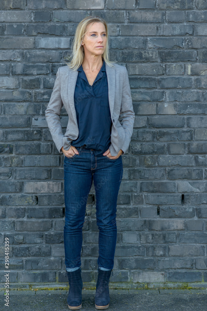 Middle-aged fit woman wearing cool slim blue jeans