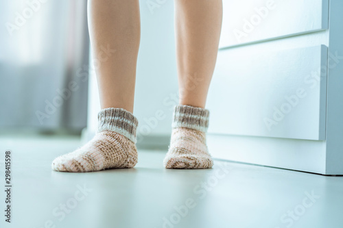 Female legs in cozy soft comfortable knitted winter socks at home