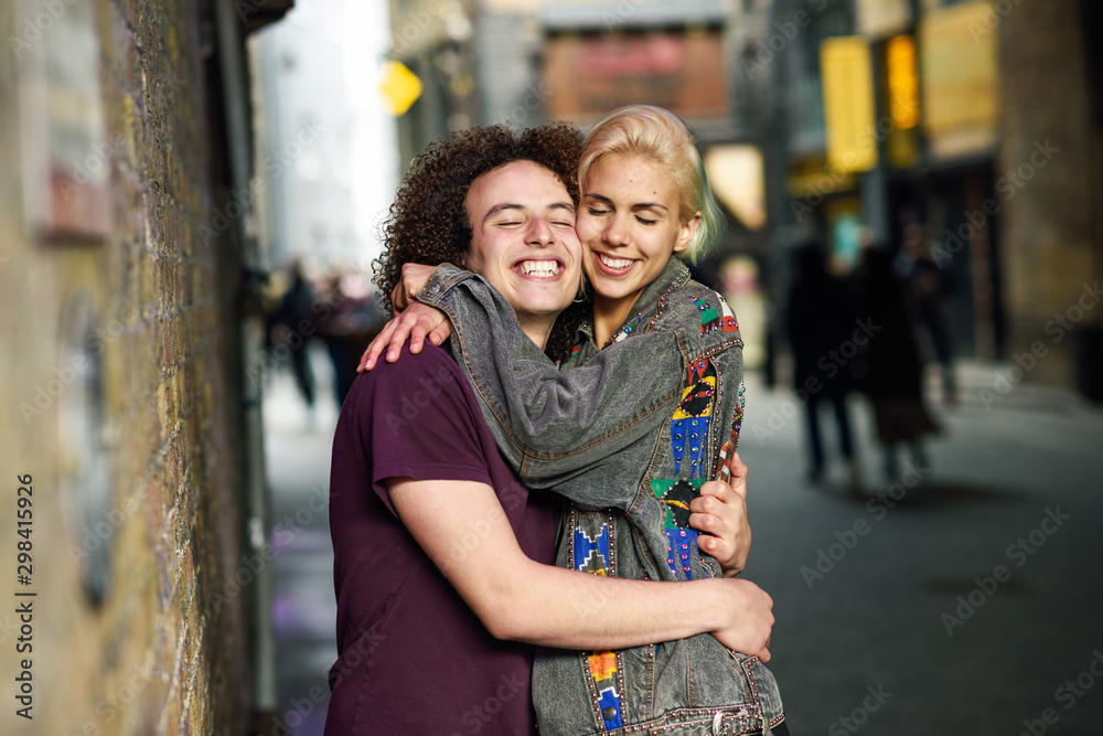 Young couple hugging in urban background on a typical London street. Young couple hugging in urban background on a typical London street.