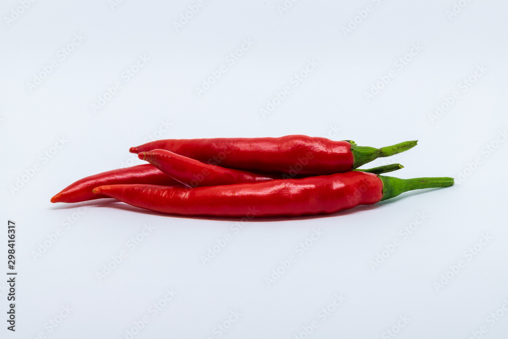 A pile of fresh red chili peppers isolated on a white background