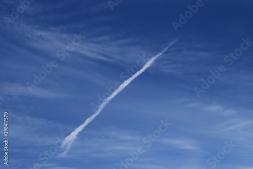 smoke airplane flying over the blue sky and clouds © Thanasarn