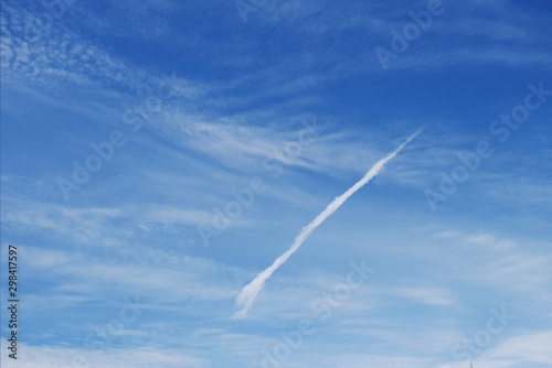 smoke airplane flying over the blue sky and clouds © Thanasarn