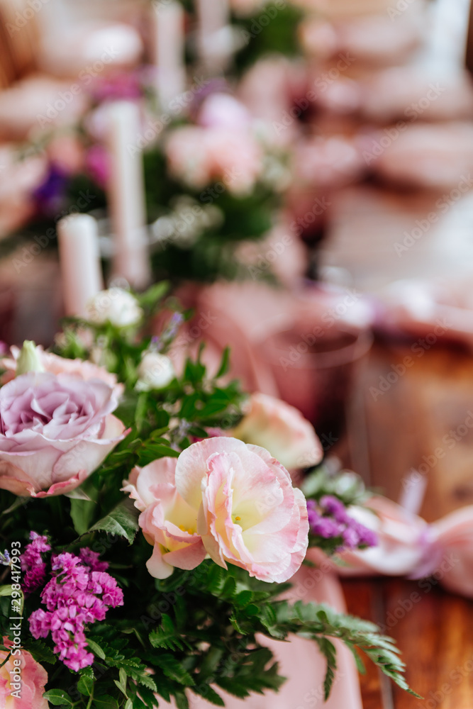 Obraz premium Vintage festive table setting with pink roses, candles and cutlery on an old wooden board