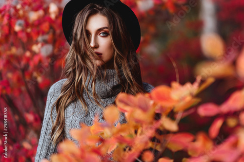 Fashion woman on a background of red and yellow autumn leaves