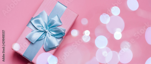 Banner of Gift box with Blue ribbon on Pink background for copy space. Christmas minimal concept idea.