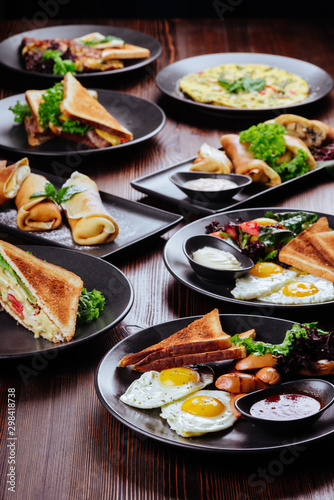 Breakfast food table. Festive brunch set, meal variety with fried egg, pancakes, croissants, smoothie ,fresh berries and fruits. Overhead view