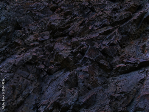 Black rock texture. Dark blue stone grunge background. Mountain close-up. Crashed. Background with space for design.