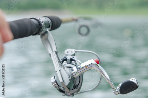 Fisherman with rod, spinning reel on the lake