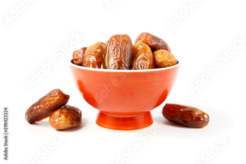 Close up fruits of date palm in brown bowl on white background