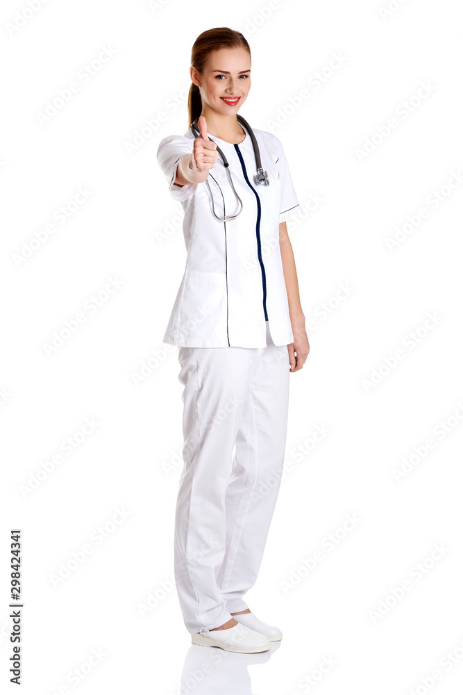 Smiling medical doctor woman or nurse standing on white background with thumb up. Smiling medical doctor woman or nurse standing on white background with thumb up.
