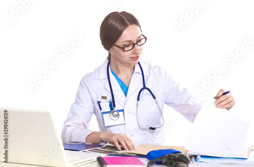 Portrait of young female doctor sitting at desk in hospital