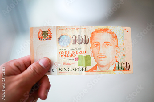 Wallpaper Mural Hand hold a 100 singapore dollar banknote ready for shopping, Singapore currency many value in shopping. Torontodigital.ca