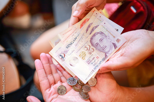 Hand hold a singapore dollar banknote ready for shopping, Singapore currency many value in shopping. photo