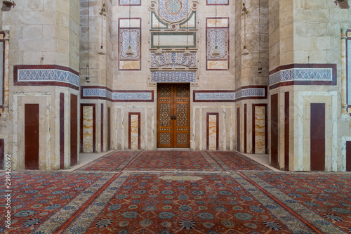 Old decorated stone wall with marble decorations and arabesque decorated wooden door in an al Refai historic public mosque, Cairo, Egypt photo