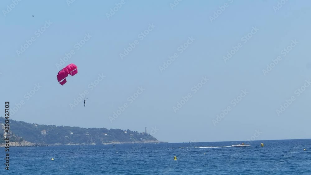 Speedboat is driving with a parachute at the end of a rope on the Mediterranean. Speedboat is driving with a parachute at the end of a rope on the Mediterranean.