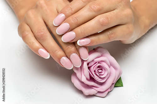 Classic manicure. Wedding nail design. White manicure. French Manicure on oval nails with a pink flower. Rose with nails.