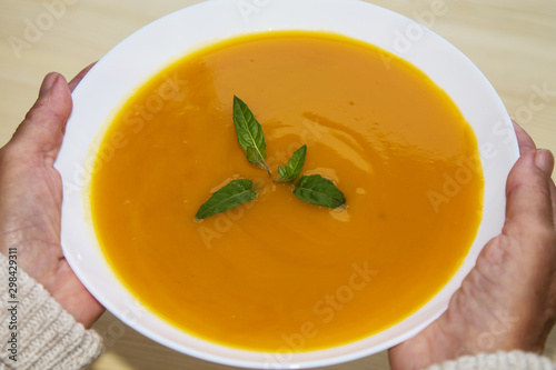 woman holding bowl of vegetable soup