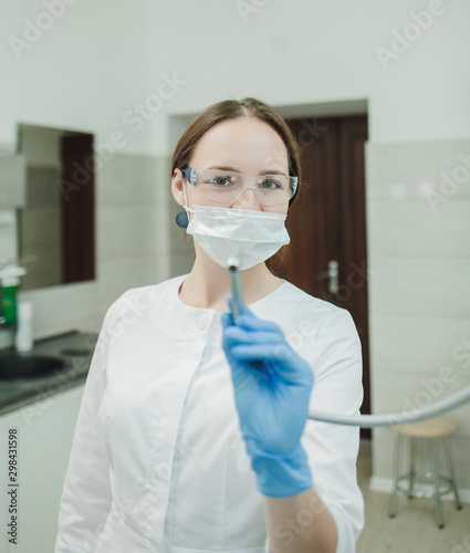 dentist doctor in protective glasses with dental instrument
