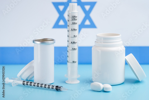 Coins stacked on each other in different positions on colored background. Pharmaceutical industry in Israeli.