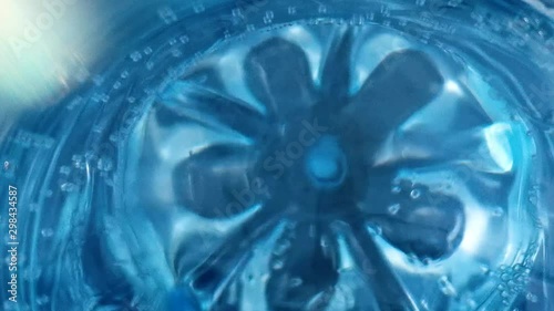 Pure water in a bottle of blue color. Water soda in a blue plastic bottle close up with small bubbles