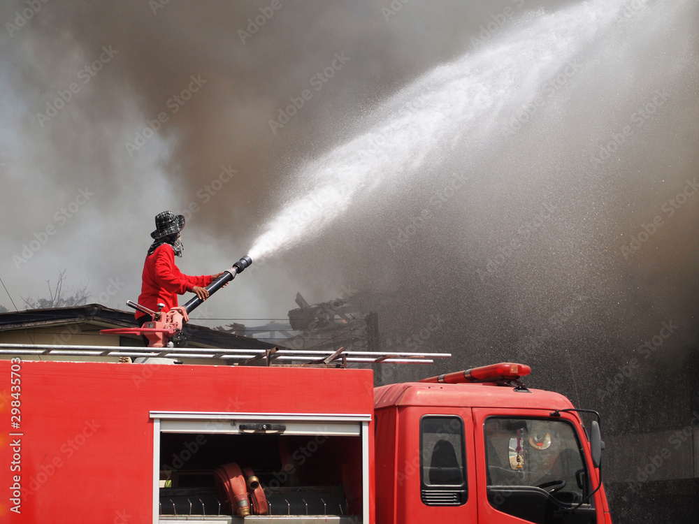 Obraz premium Fireman are spraying water to put out fire.