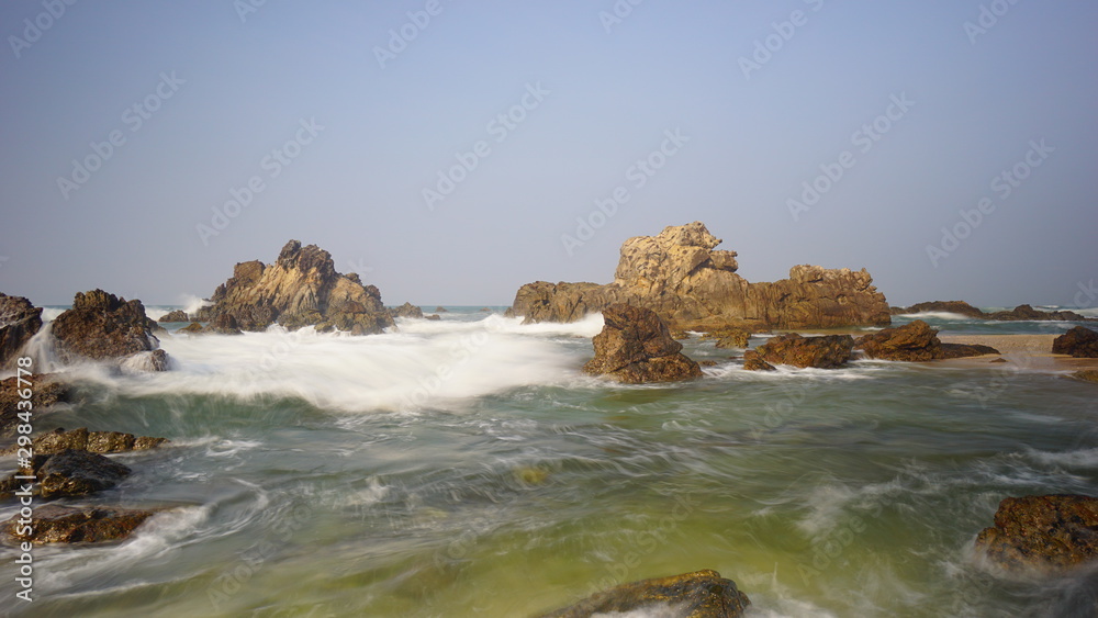 The splashing sea water in the red rock Karang Beureum beach, anten Province The splashing sea water in the red rock Karang Beureum beach, anten Province