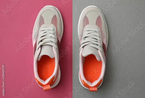 Stylish women's sneakers on color background, top view