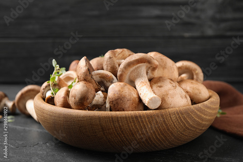 Fresh wild mushrooms in bowl on black table