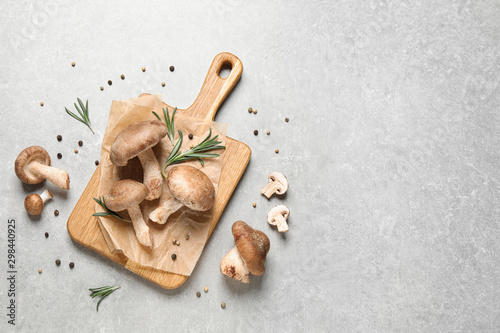 Flat lay composition with fresh wild mushrooms on light grey table, space for text
