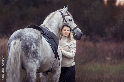 Beautiful girl posing with a purebred arabian horse outdoors. 