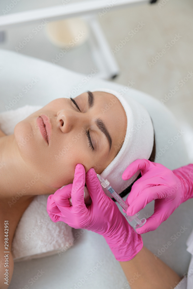 Relaxed young woman receiving beauty injection at sap salon