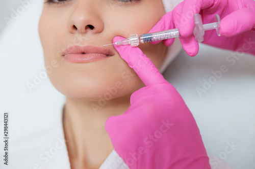 Young lady receiving beauty injection at spa salon