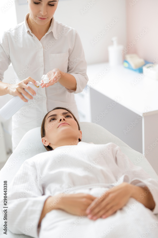 Beautician spraying purifying foaming cleanser on her hand Beautician spraying purifying foaming cleanser on her hand