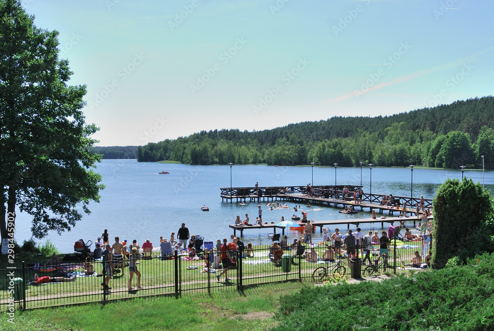 Obraz premium Crowded lake beach on a sunny summer weekend day