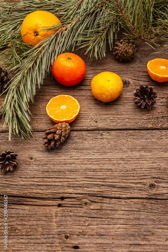 Fototapeta Naklejka Na Ścianę i Meble -  Spirit Christmas background. Fresh oranges, tangerines, pine branches and cones. Nature decorations, vintage wooden boards