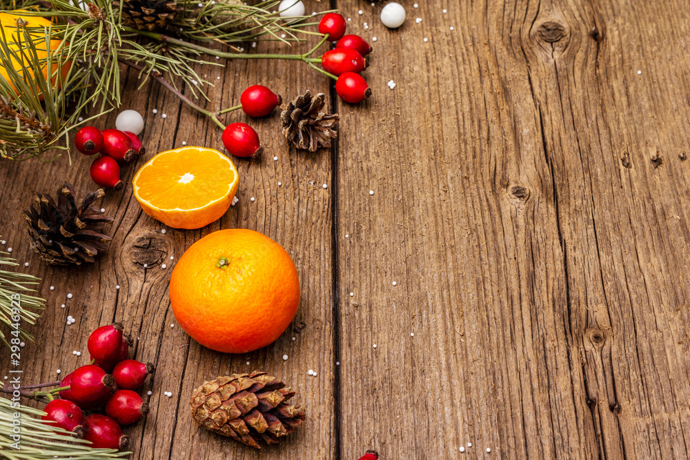 Spirit Christmas background. Fresh mandarins, dog-rose berries, candies, pine branches and cones, artificial snow Spirit Christmas background. Fresh mandarins, dog-rose berries, candies, pine branches and cones, artificial snow