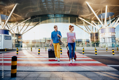 Excited couple hurrying to plane with luggage stock photo