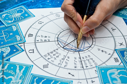 astrologer fortune teller with quill pen, horoscope, zodiac like astrology concept  photo