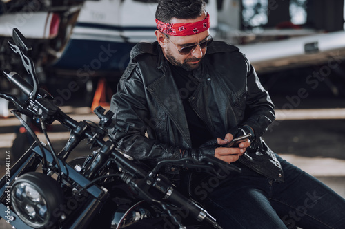 Caucasian bearded biker sitting on classic style motorcycle