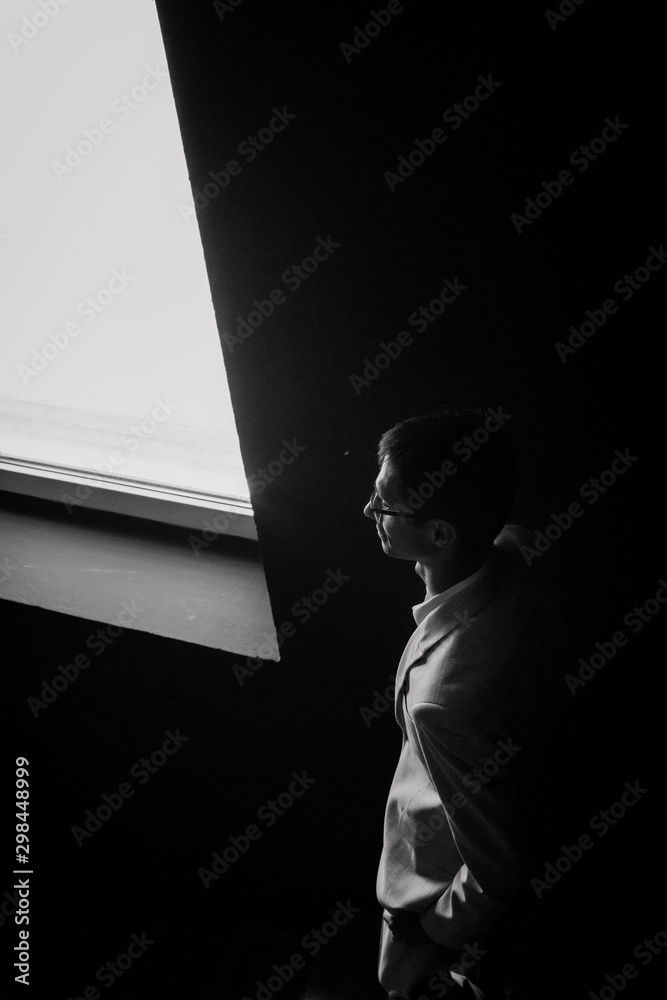 man portrait inside stands window profile room