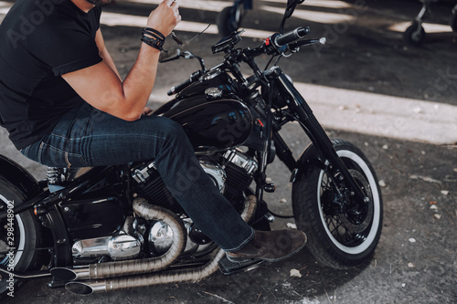 Male biker is sitting on his black motorcycle © Yakobchuk Olena