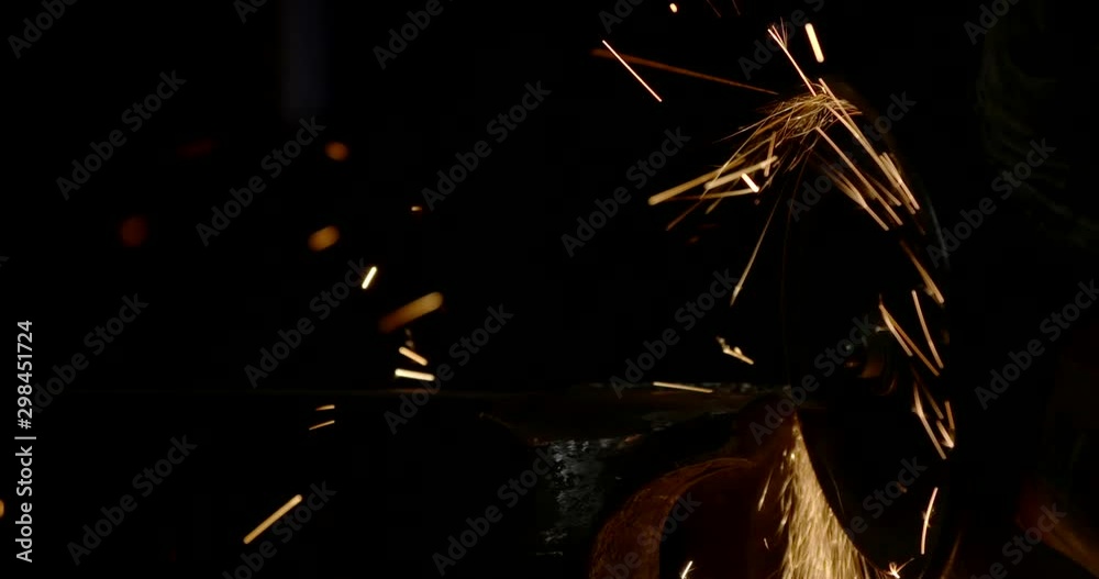 Male hand cuts off pieces of water pipe with angle grinder. Cutting of a steel with splashes of sparks at construction site. Sparks during cutting of metal angle grinder