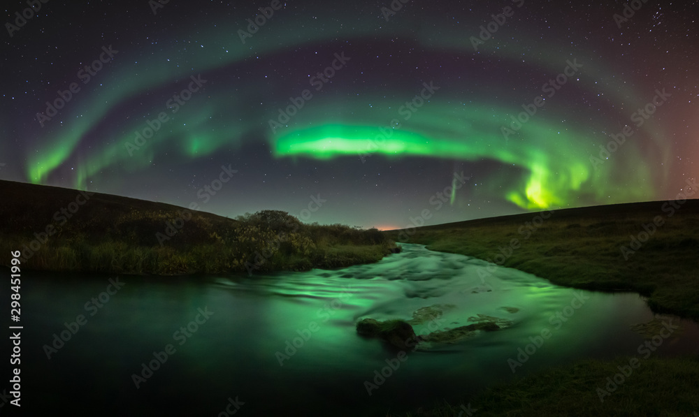 Northern lights with reflection in river, North Iceland