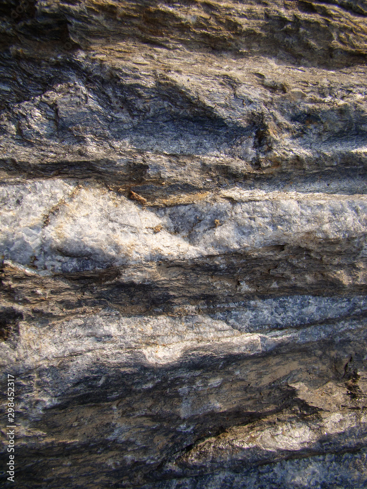 Rock formation with a layered gray-light structure. Vertical layout. Rock formation with a layered gray-light structure. Vertical layout.